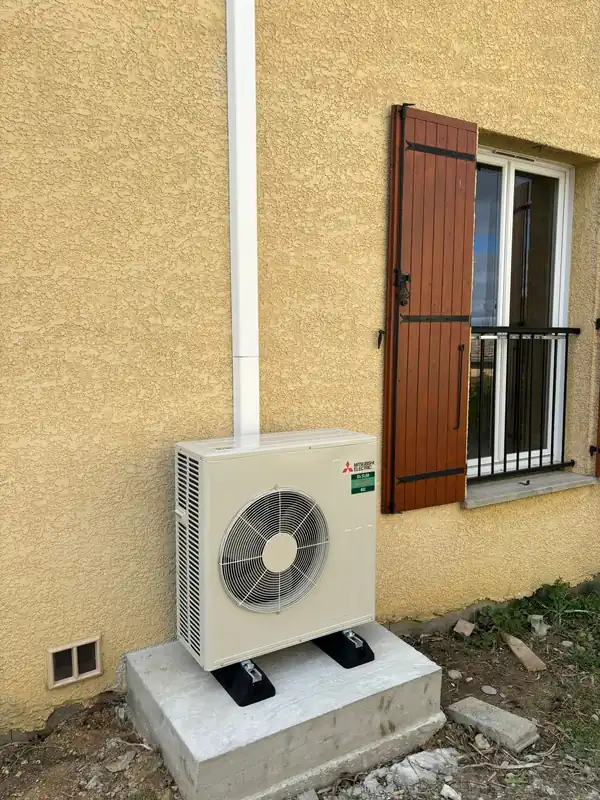 Pompe à chaleur air-air installée sur socle béton en maison individuelle